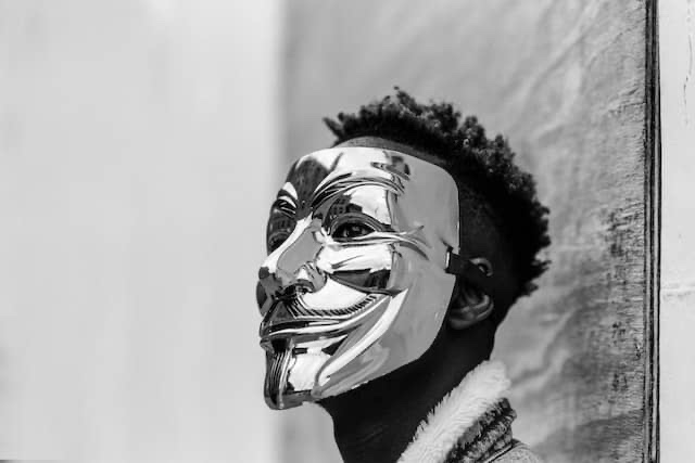 African-American man wearing a full face masquerade mask.